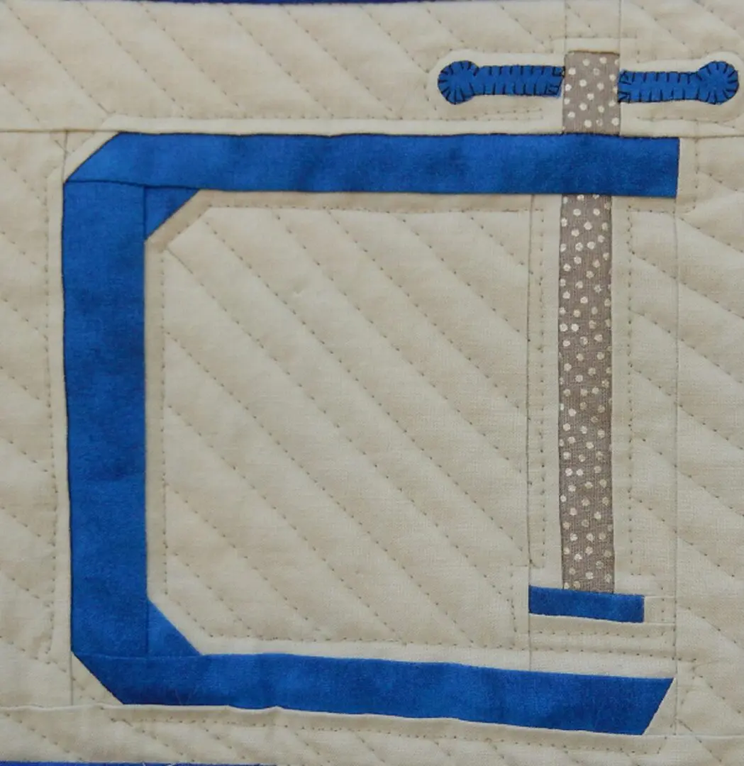 A quilt with the letter c on it.