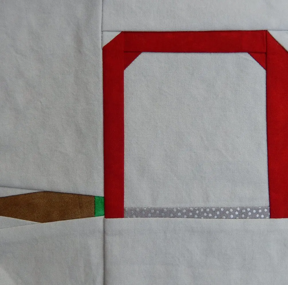 A close up of the paddle and red frame on a quilt