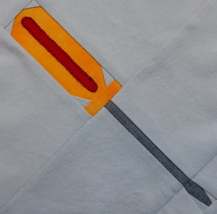 A yellow and red screwdriver on top of a white sheet.