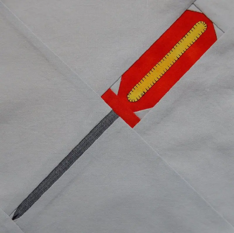 A red and yellow screwdriver is on top of a white cloth.