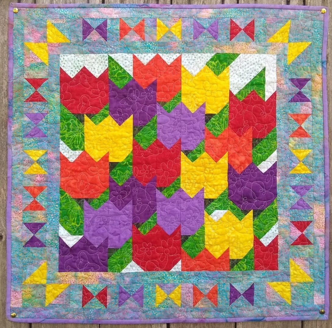 A quilt with colorful flowers and butterflies on it.