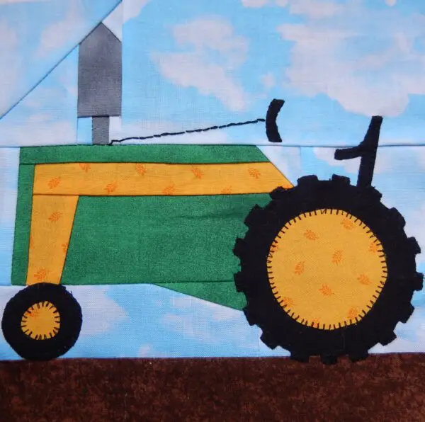 A quilt block with a tractor on it.