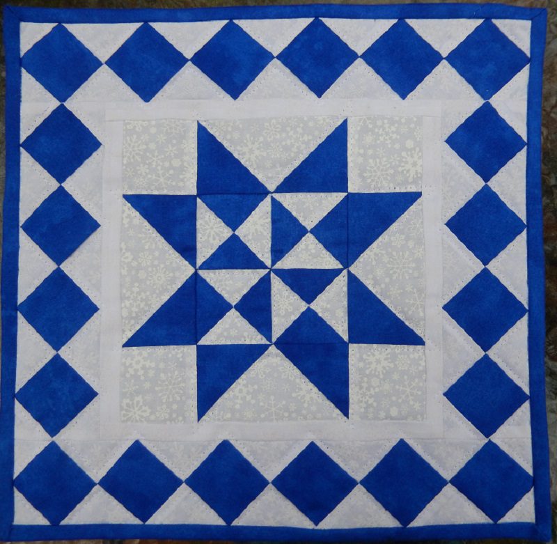 A Snowflake Mini Quilt with a star in the middle.