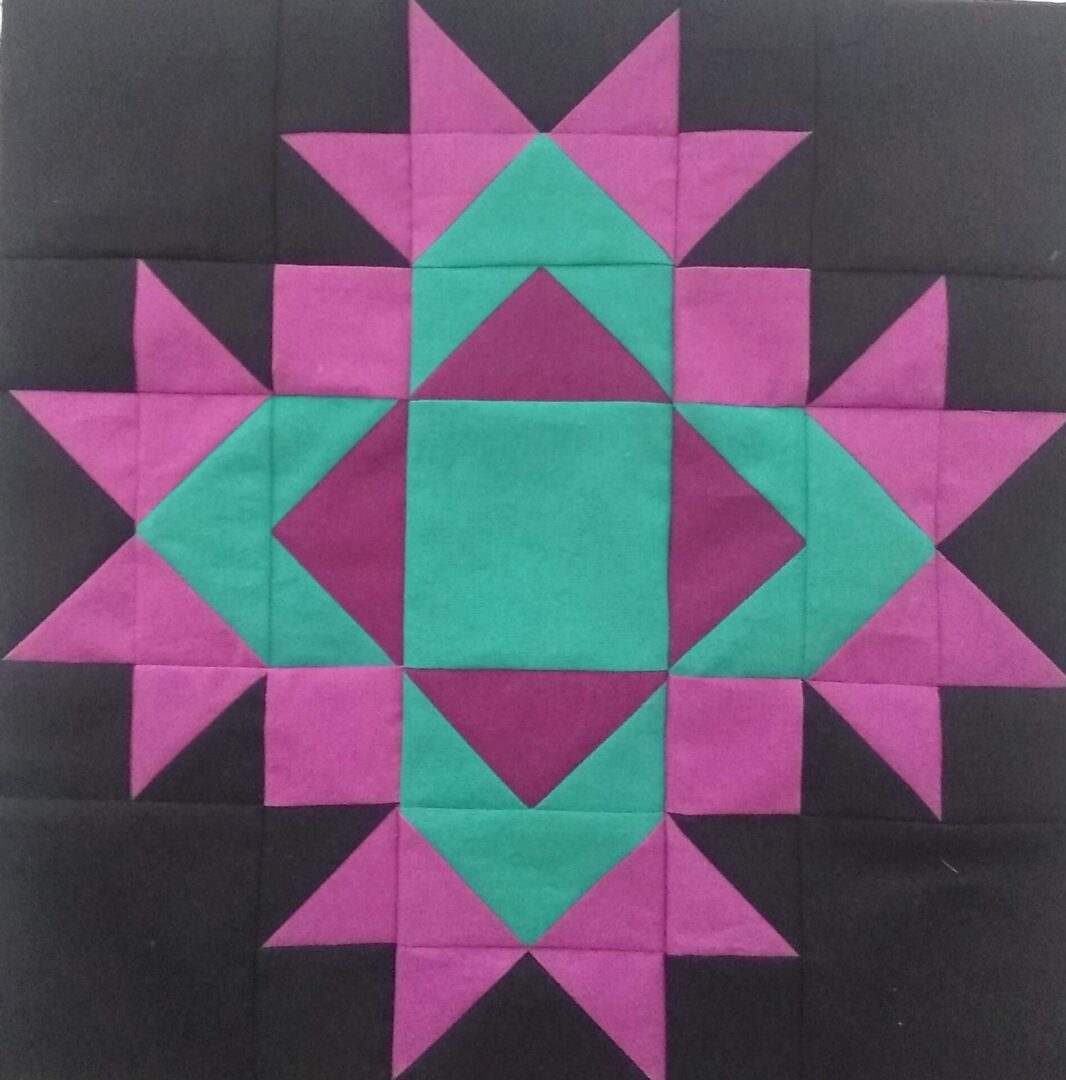 A black and purple Thistle Bloom quilt block with a star in the middle.