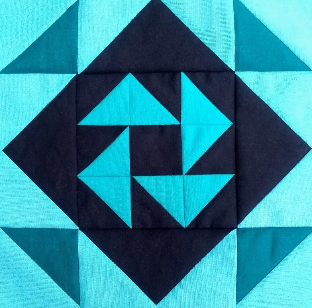 An Album Road quilt block with a triangle in the middle.