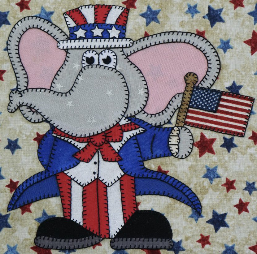 A patriotic Elephant - July with an American flag on his head.