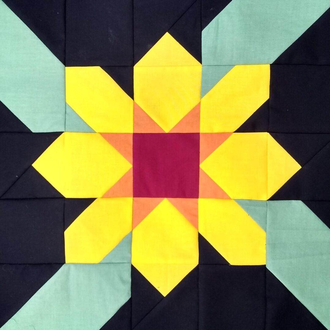 A Black Eyed Susan quilt block with a yellow flower.