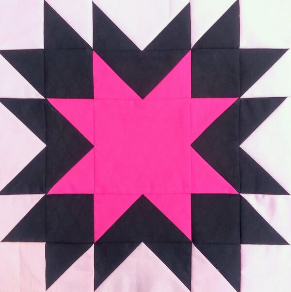 A Memory quilt block with a pink and black star.