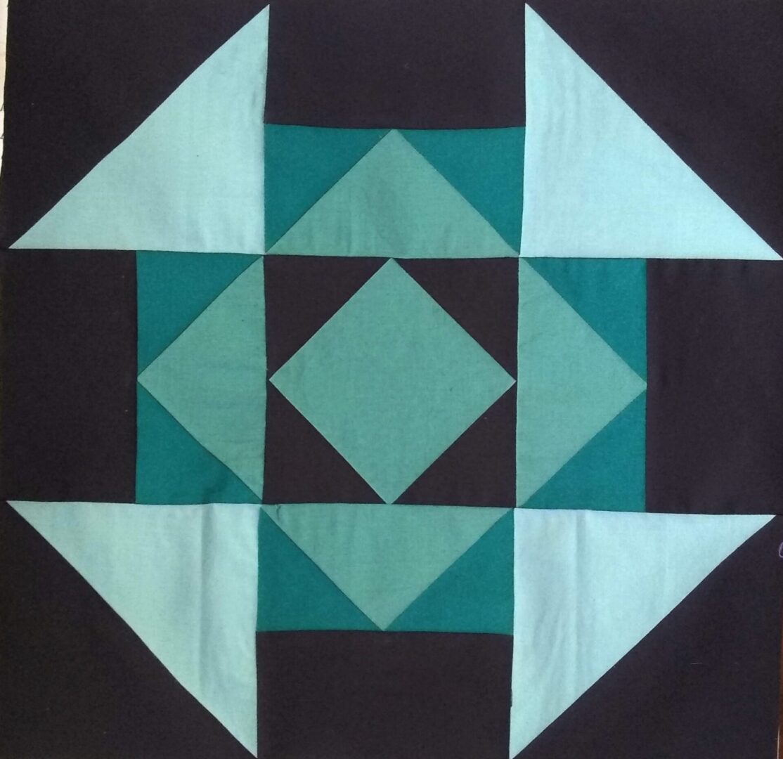 A blue and black Hansel and Gretel block with a triangle in the middle.