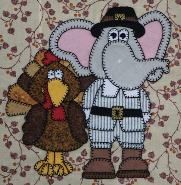 An November and a turkey are appliqued on a piece of fabric.