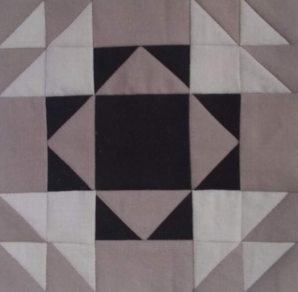 A Hands of Friendship quilt block with black and white squares.