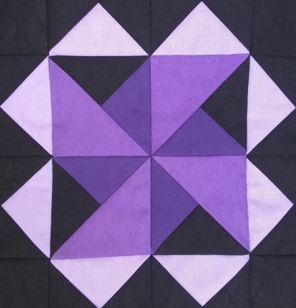 A Millstone quilt block with purple and black squares.