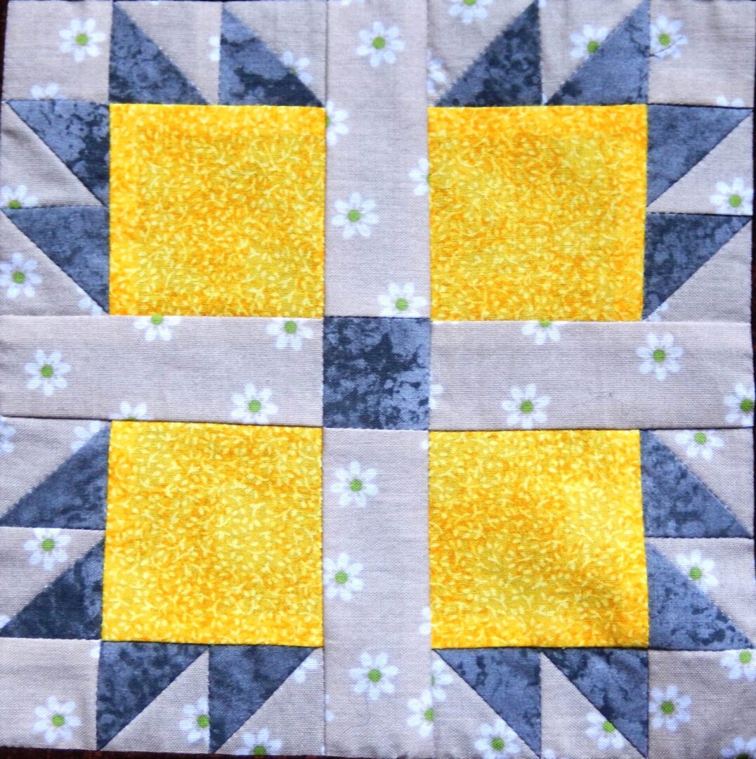 A Bears Paw block with yellow and gray squares.