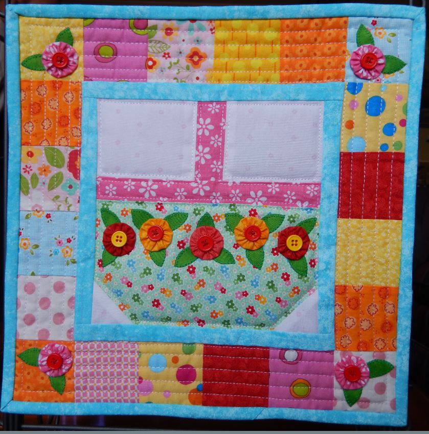 A Spring Basket Mini Quilt hanging on a wall.