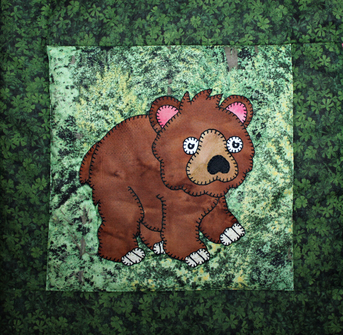 A brown Bear appliqued on a green background.