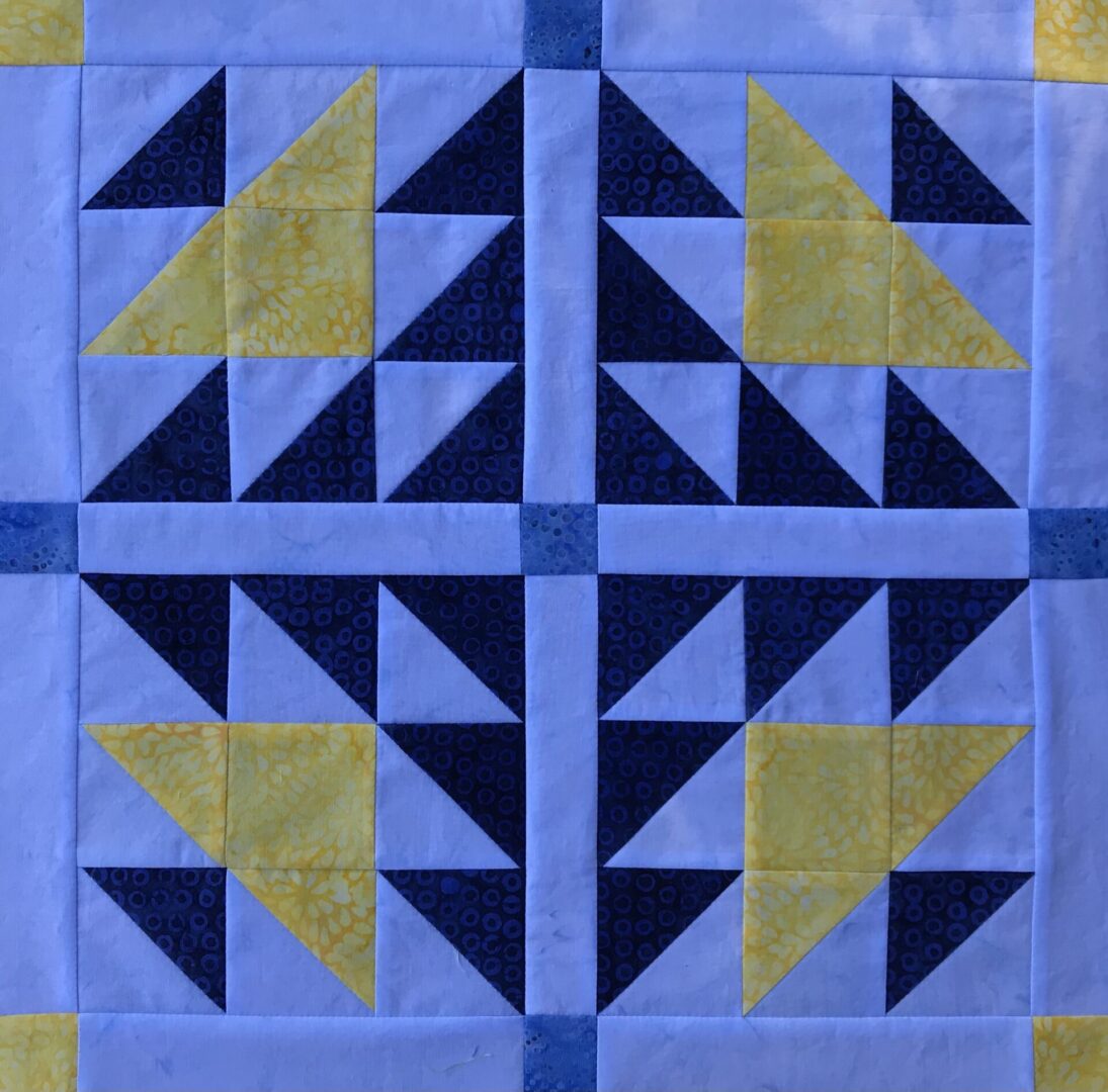 A black and yellow quilt block with triangles.