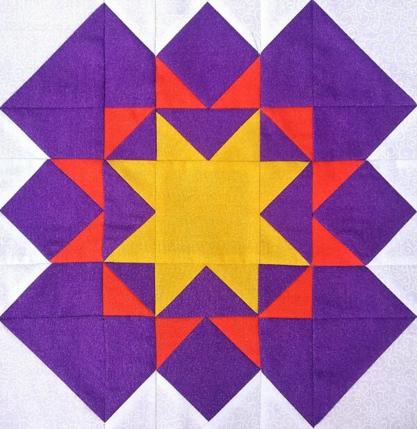 A purple and yellow quilt block with a Blazing Star in the middle.