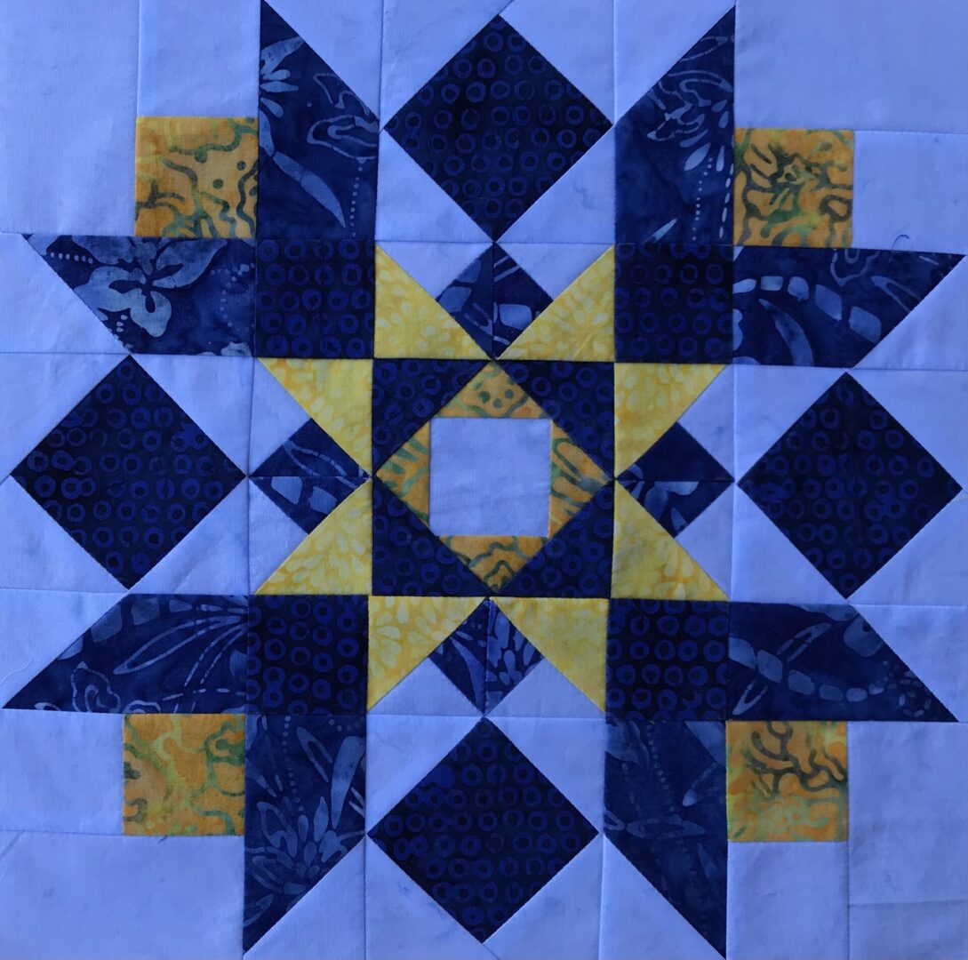 A Blue Ridge Mountain Star quilt block with blue and yellow squares.