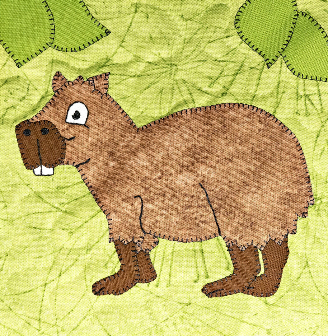 A capybara is standing next to a leaf.