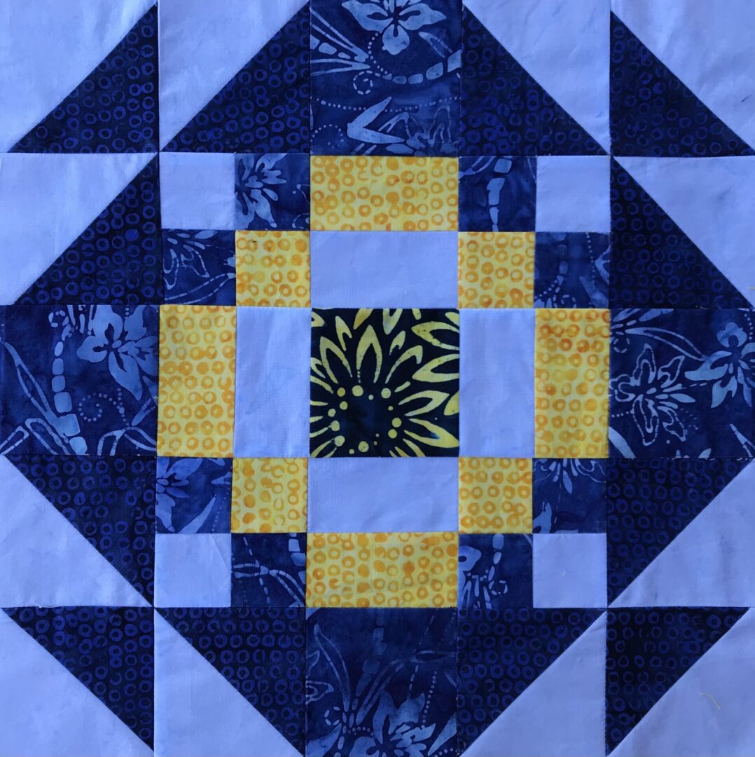 A blue and yellow China Doll quilt block with yellow squares.
