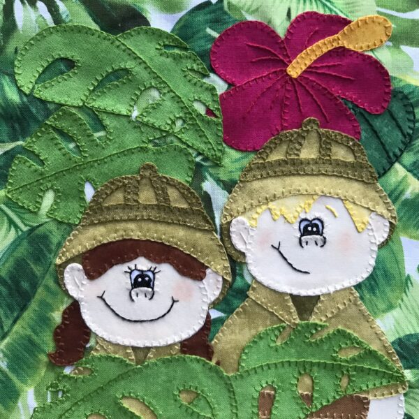 Two Congo Kids are embroidered on a piece of fabric.