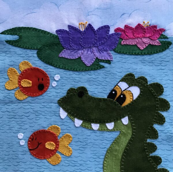 Crocodile with fish and lilies on a wall hanging.