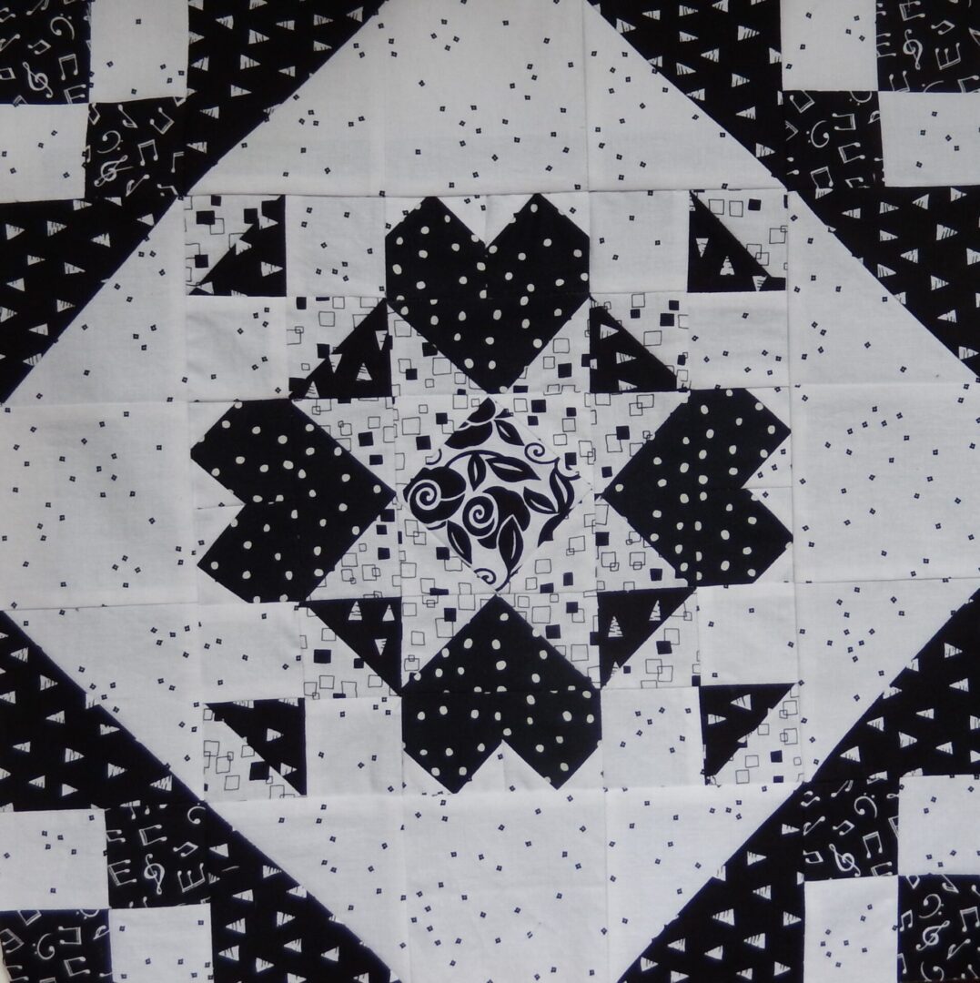 A black and white Cross My Heart quilt with hearts on it.