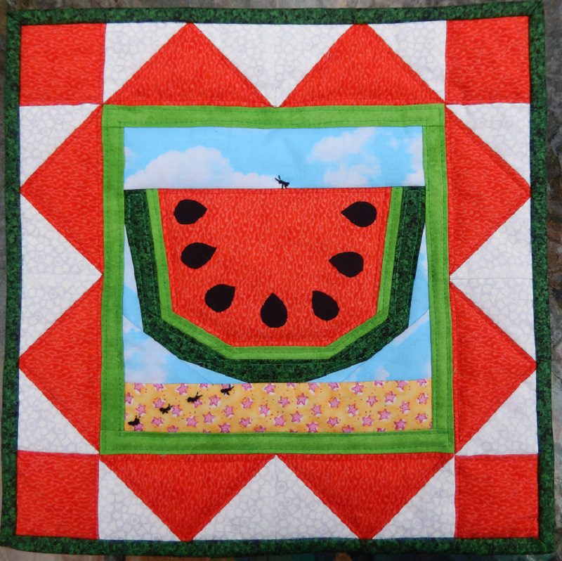 A Summer Picnic Mini Quilt hanging on a wall.