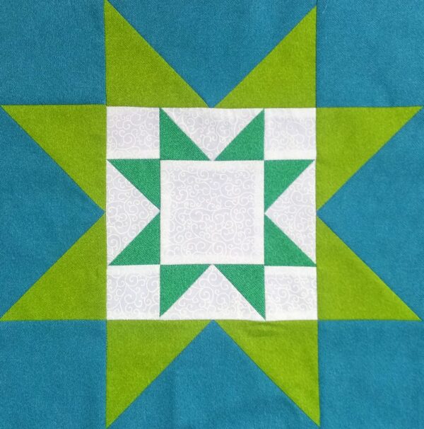 A quilt block with a green and blue Double Star.