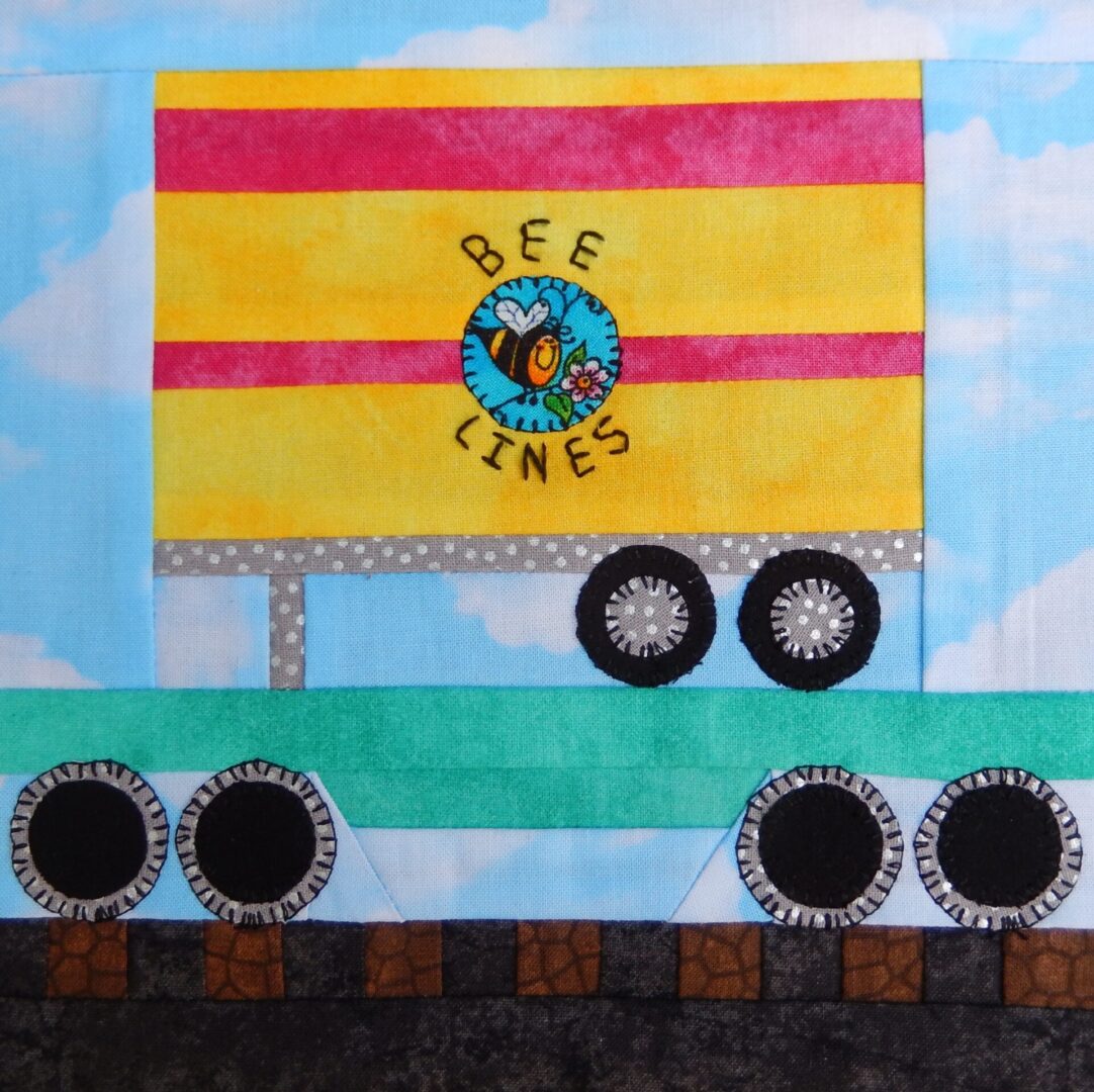 A quilt with a flatcar with trailer on it.
