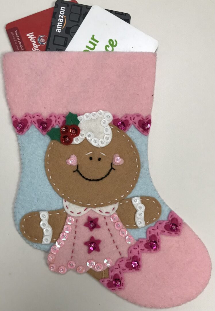A Gingerbread Girl B Gift Card Holder stocking with credit cards in it.