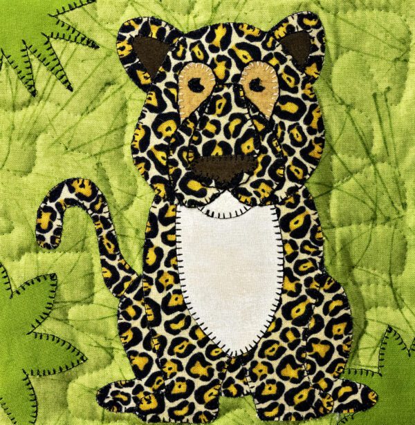 A jaguar appliqued on a green background.