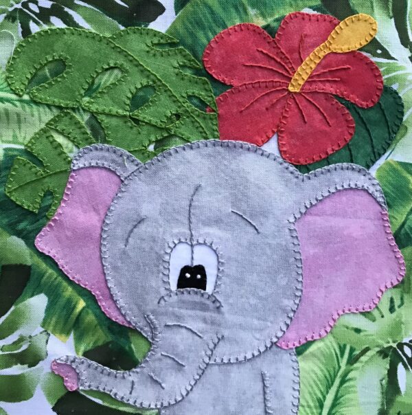 A Jungle Elephant with a flower on his head is embroidered on a piece of fabric.