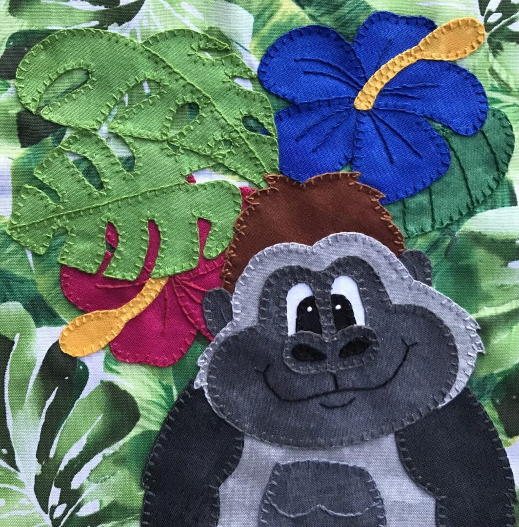 A gorilla with flowers and leaves on a piece of fabric.