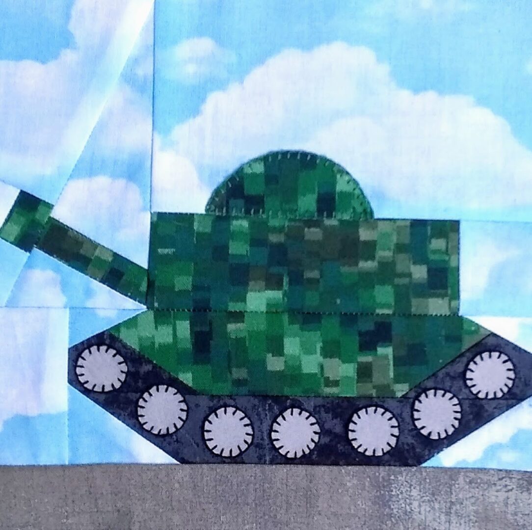 A quilt block with a military tank on it.