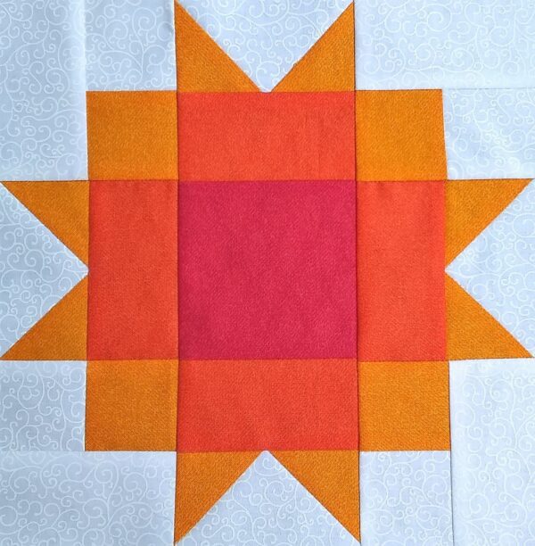 A Maple Star quilt block with orange and pink squares.