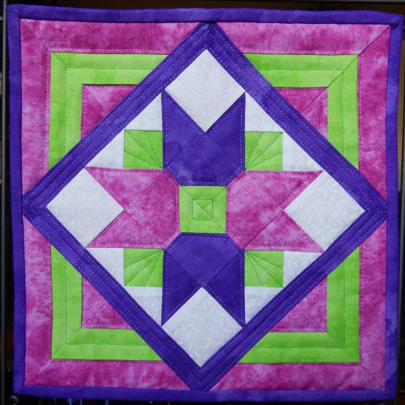 A Tulip Bouquet Mini Quilt hanging on a wall.