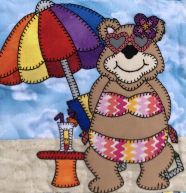 A Momma Bear wearing a bikini and holding an umbrella.