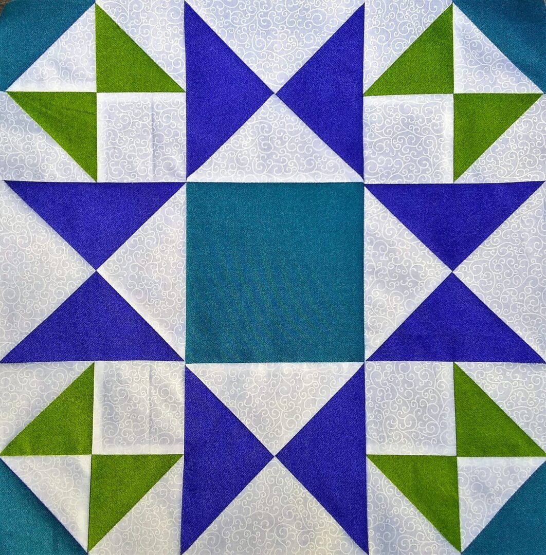 A Morning Star quilt block with blue and green triangles.