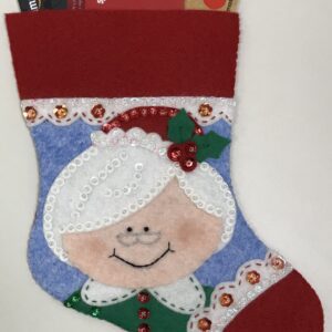 A Christmas stocking with a Mrs. Santa Claus Gift Card Holder in it.
