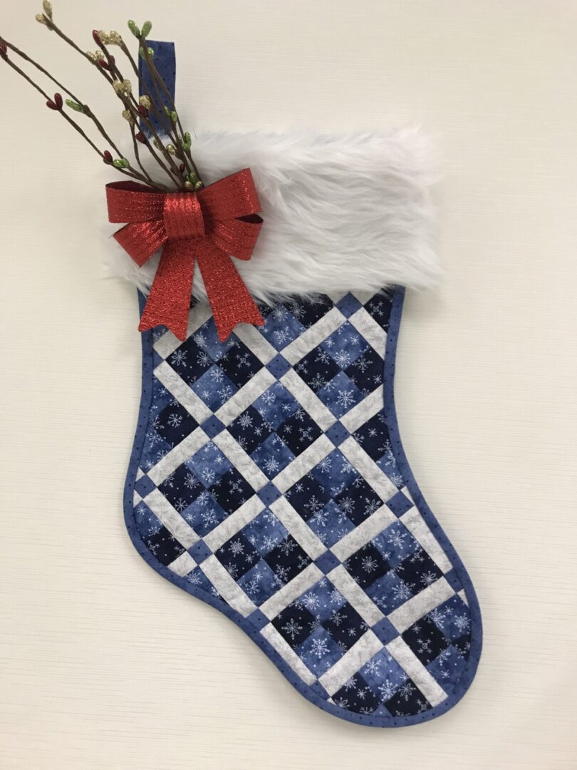 A Ms. P's Pieced Christmas Stocking with a bow.