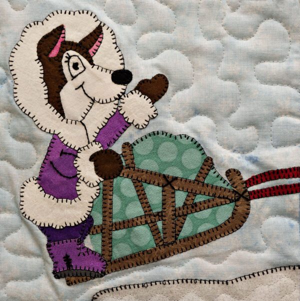 A quilt with a Husky - Musher on a sled.