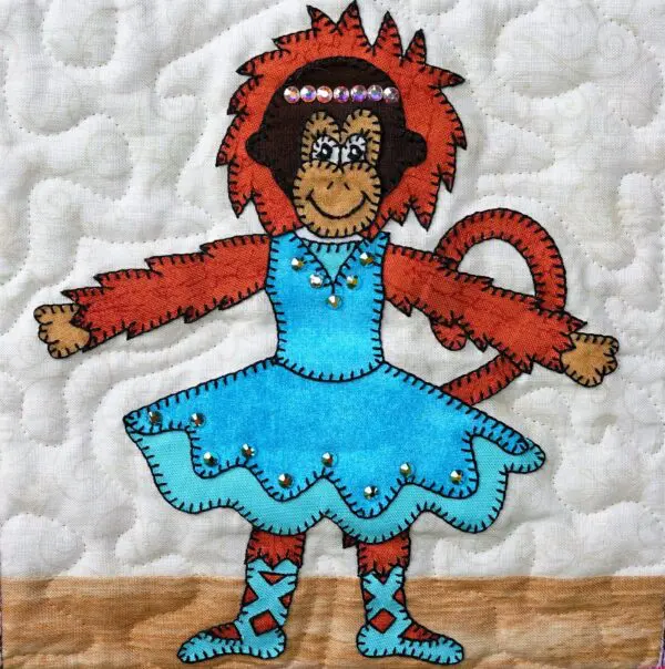 A quilted wall hanging with a Dance - Orangutan in a blue dress.