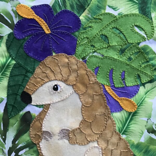 A Pangolin is embroidered on a piece of fabric.