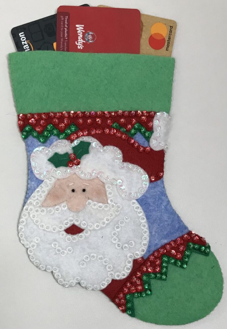 A Santa Gift Card Holder stocking with credit cards in it.