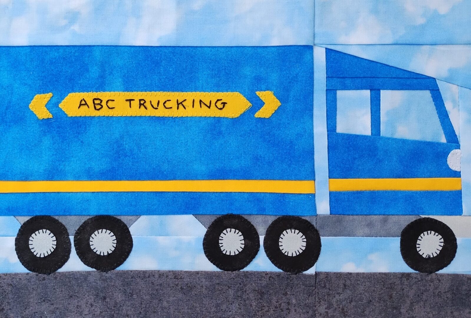 A blue and yellow quilt with the words Semi-Truck Big Rig on it.
