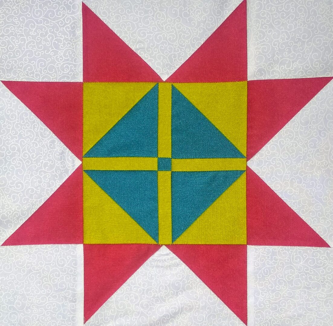 A quilt block with a Shoo Fly Star on a grey background