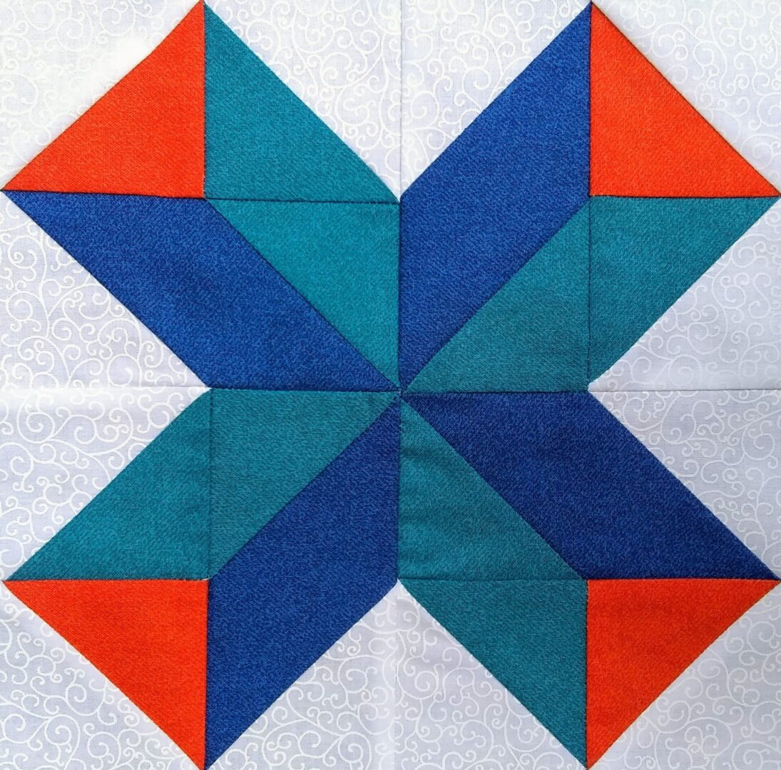 A Shooting Star quilt block with blue and orange triangles.