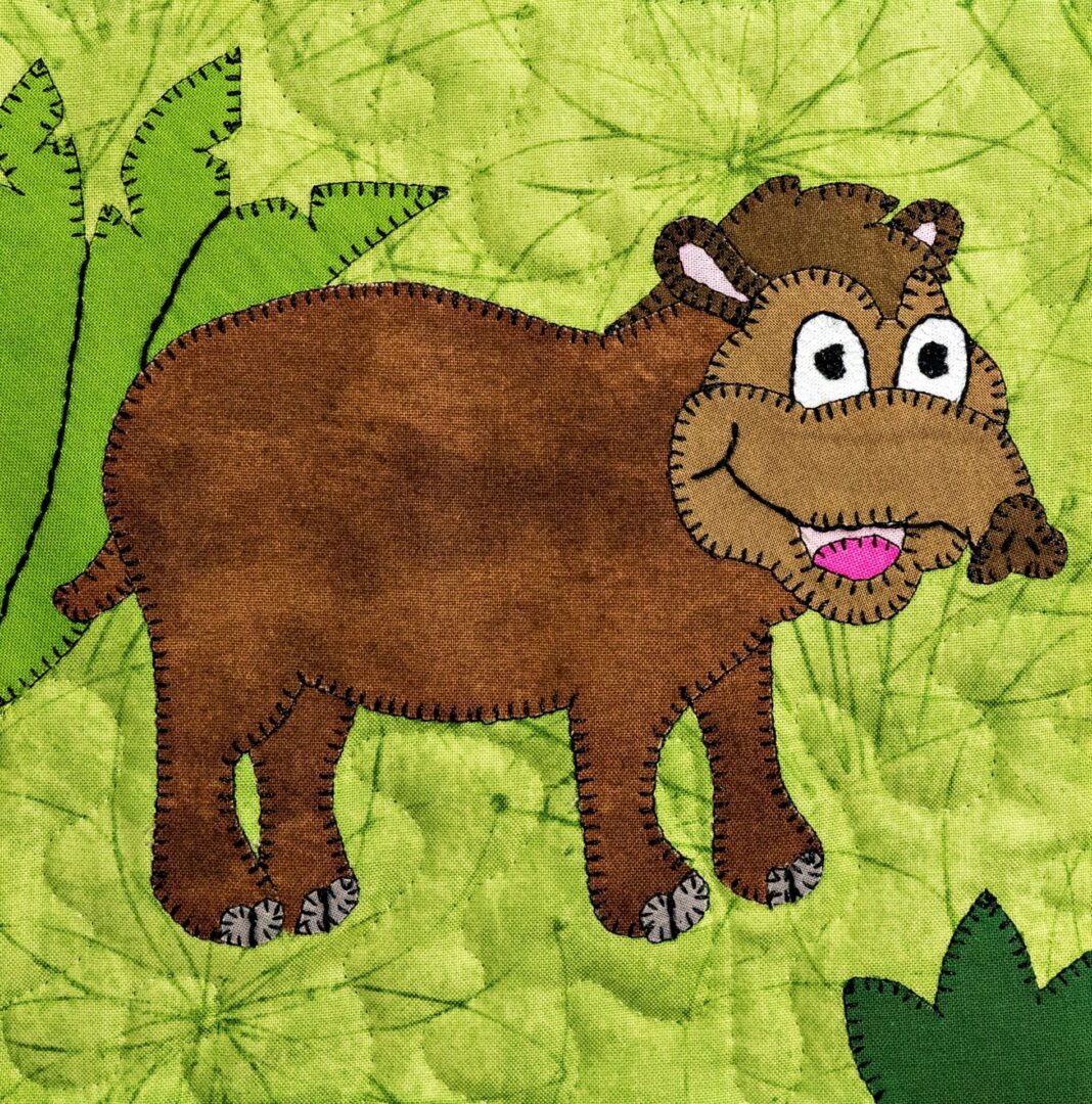 A tapir is standing in a green field with leaves.