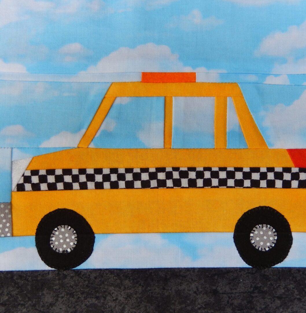 A quilt with a Taxi Cab on it.